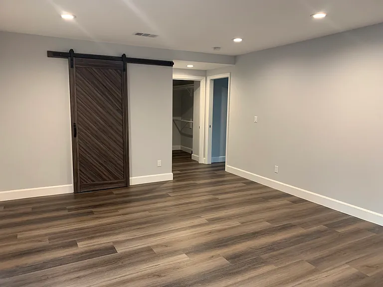Primary bedroom with barn door primary bathroom