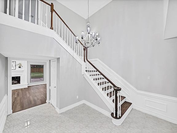 Spectacular first impression in the formal entry that features an updated contemporary chandelier and wood staircase.