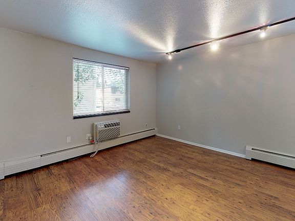 Bright living space with track lighting and hardwood floors