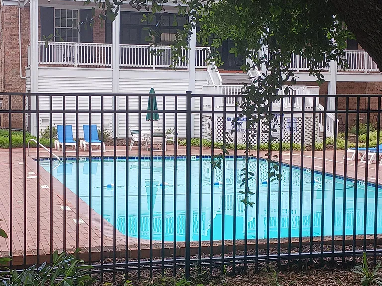 Community building that houses the exercise room, meeting rooms, event space and HOA office. First pool is outside with lounge chairs.