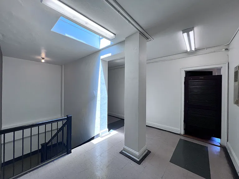 The apartment's front door is located right off of the stairwell.