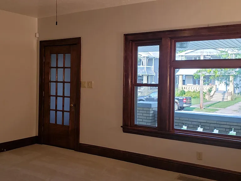 Living room with view of front porch and street.