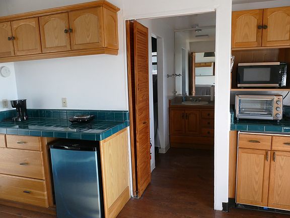 There is a built-in Freezer (new) and re-conditioned refrigerator . On the counter is a large, portable oven and toaster s well as microwave. A portable burner is provided and coffee pot. You see the hall to the bath and closet. There is a French door
