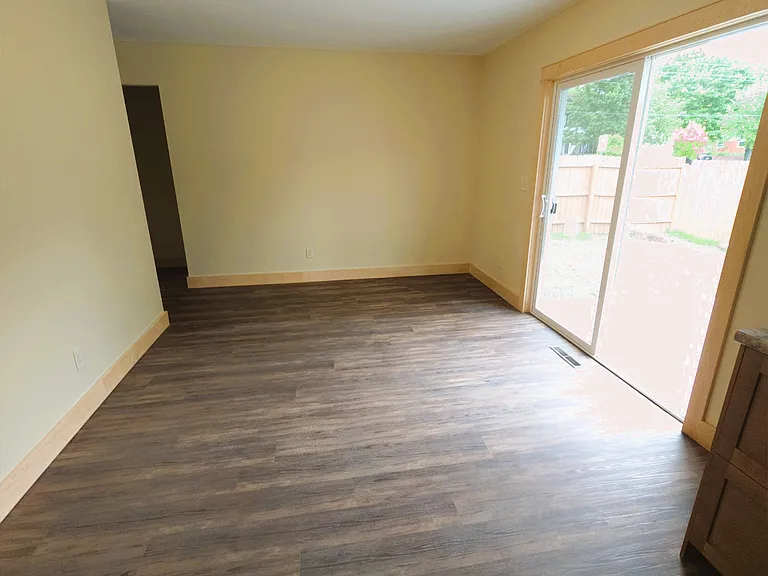 Large Dining Space with patio doors to newly poured concrete patio and fenced in backyard.