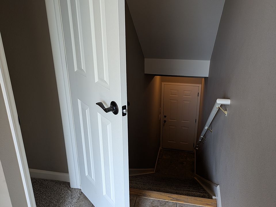 Stairs leading down to the garage and a coat closet that is near the front door.