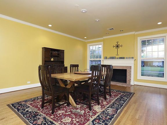 Living/Dining area overlooking beautiful front yard with lovely brick fireplace