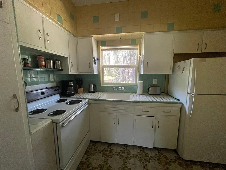 kitchen is fully equipped with stove, oven, refrigerator, coffee maker, toaster, tea kettle, blender, pots and pans, dishes, cups and mugs.