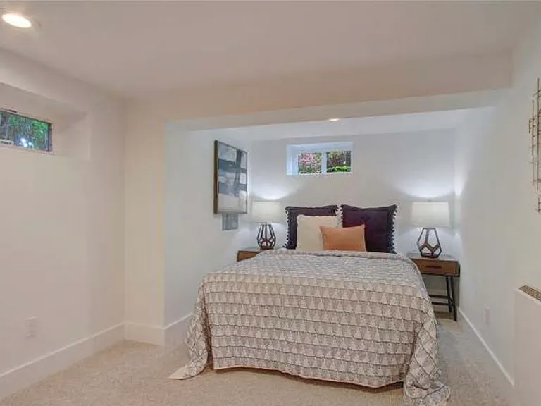 East bedroom with former furnishings (not included). Window above bed has been replaced with larger-- see unfurnished image.