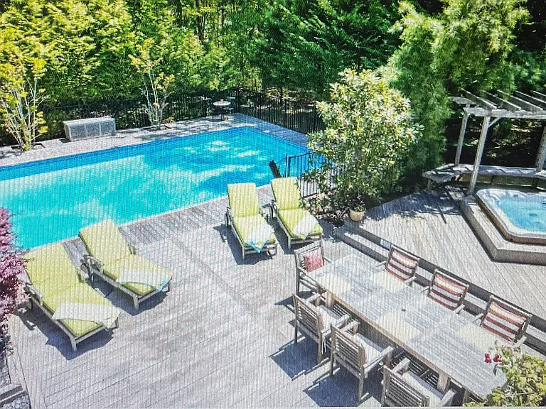 View from main bedroom balcony overlooking backyard pool, hot tub, deck