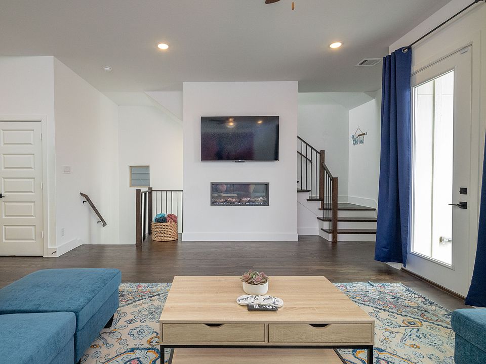 Spacious living room with vibrant pops of color, a large L-shaped couch, cozy fireplace, and TV_perfect for lounging and unwinding.