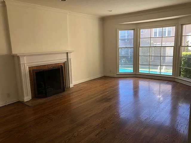 Livingroom with bay window overlooking the courtyard with a swimming pool