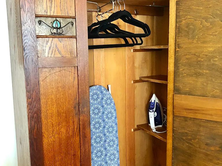 You'll have plenty of room for hanging your clothes, ample shelving, plus iron and ironing board.