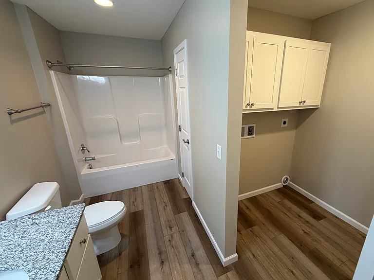 Guest bathroom with laundry. Space for any standard size residential washer and electric dryer.