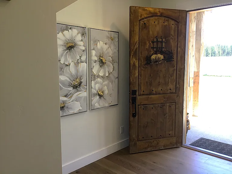 Rustic Montana-style front entry featuring a custom wood door and inviting details that warmly welcome you home.