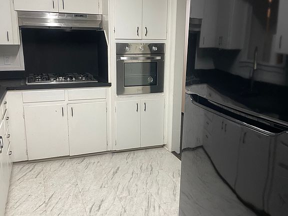 Kitchen view with refrigerator, gas stovetop, and oven