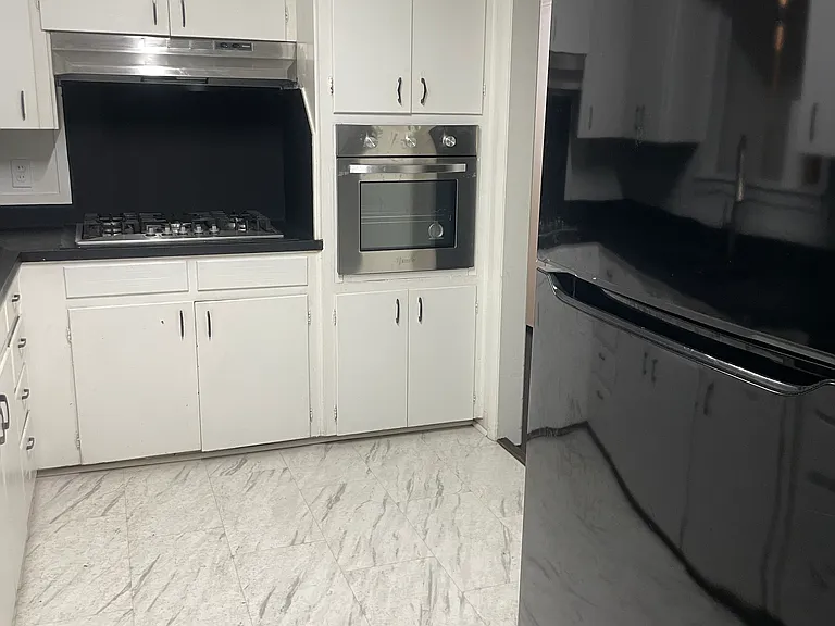 Kitchen view with refrigerator, gas stovetop, and oven