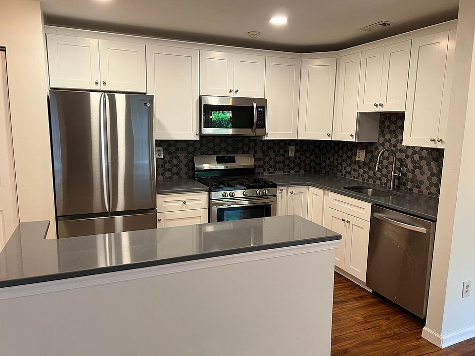 Kitchen: White shaker cabinets quartz countertop tile backsplash stainless appliances icemaker