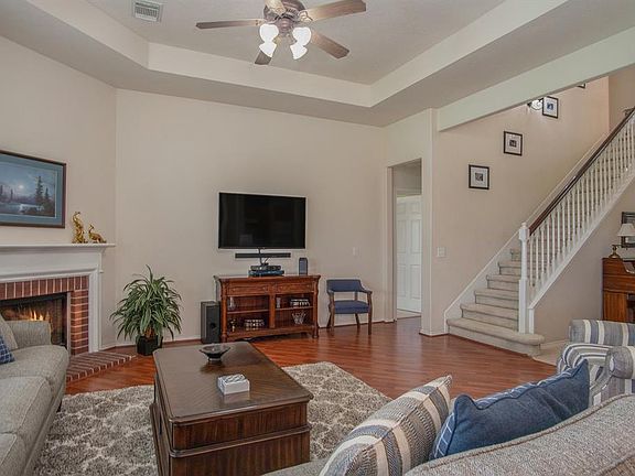 Family room with tray ceiling and laminate floors open to kitchen.