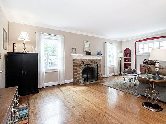 Light and bright living room with a wood burning fireplace with a nice brick mantel.