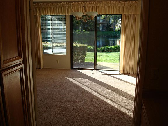 dining area adjacent to living area, view from kitchen of back patio and adjacent pond