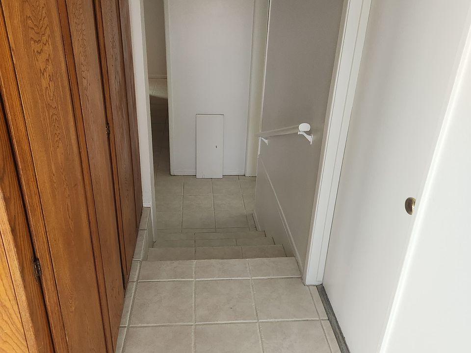 Hallway from front door to kitchen and big storage cabinets on the left with door to garage on the right