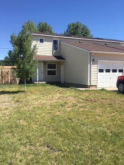 Front yard and entry with garage and driveway for off-street parking.