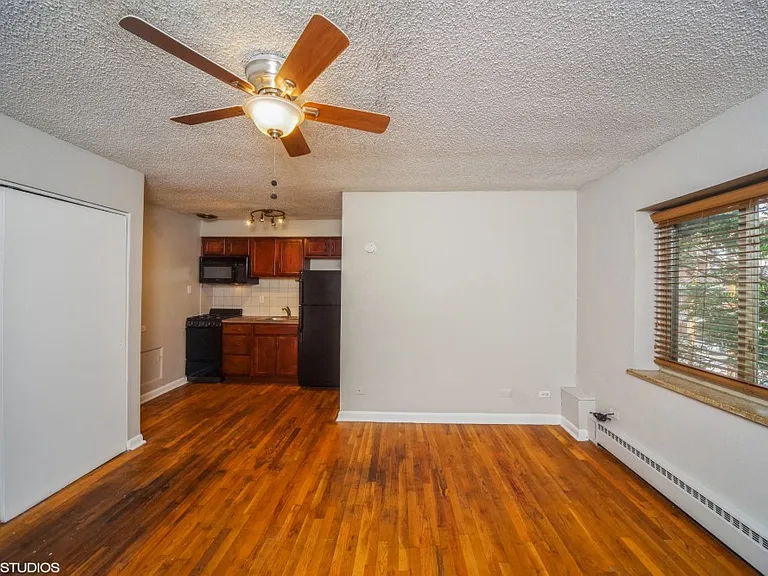 Living room with hardwood flooring and a ceiling fan