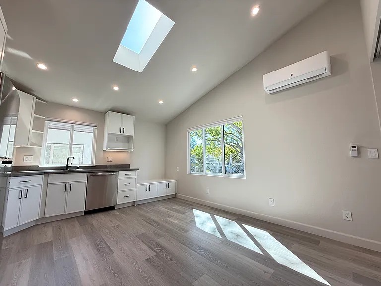 Light-filled kitchen and dining space with forward facing window and skylight.