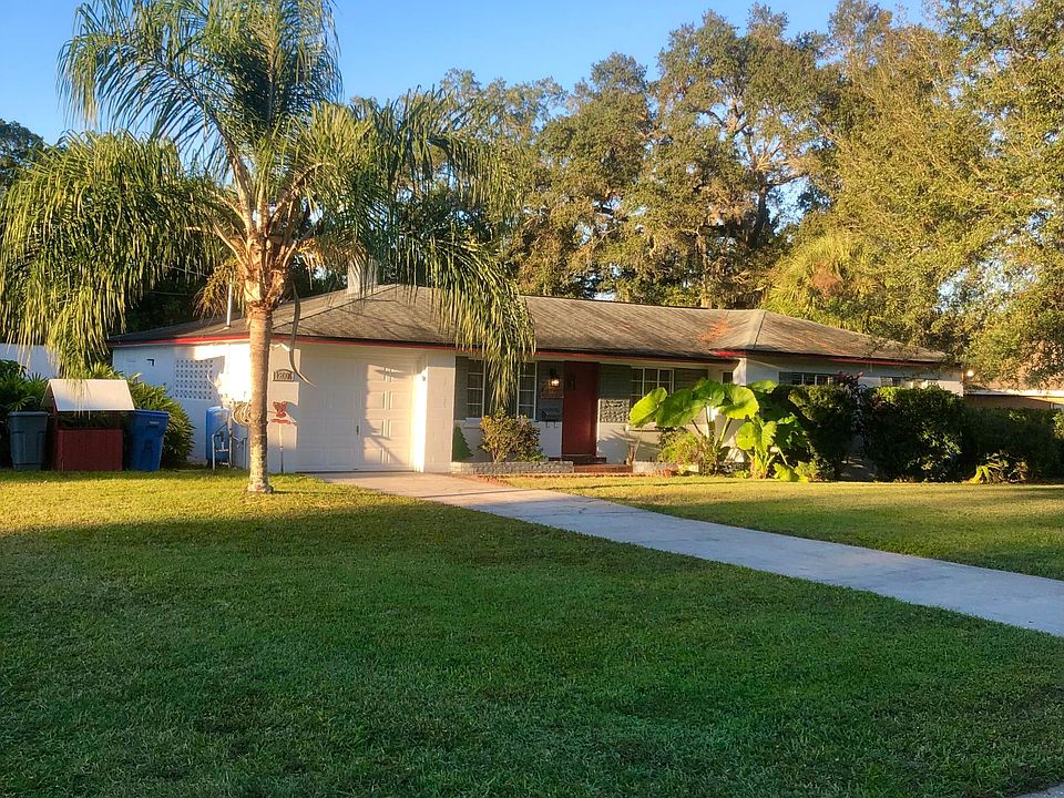 Front of house. Large lot, garage, sidewalk.