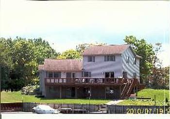 View of home from canal, showing vertical seawall andbr 12 x 44 deck wrapping around to front of hom