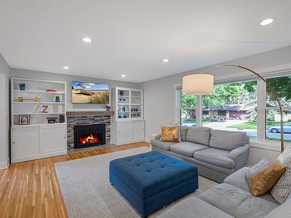 Light and bright living room with built ins on each side of the gas fireplace