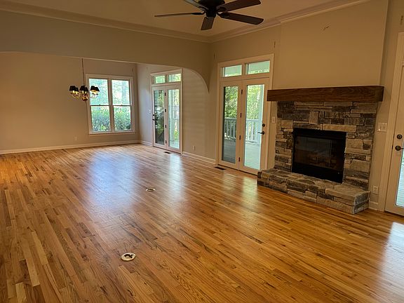 Expansive living room with access to back porch, gas log fireplace, built in cabinetry