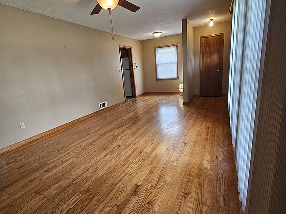 Spacious living room with nook and hardwood floors.
