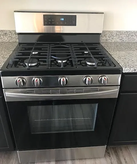 Gas range, self cleaning, with 5 burners and an even grate on top. The center burner is elongated for the griddle (to make those Sunday morning pancakes).