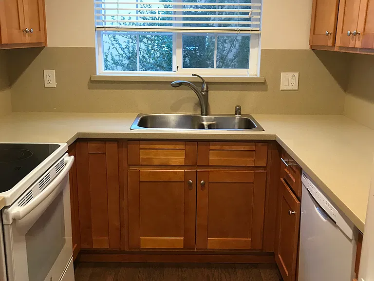 The efficient kitchen has beautiful Corian countertop, rich maple cabinets, waterproof vinyl floor, electric cooktop and oven, dishwasher and a French door refrigerator with icemaker.