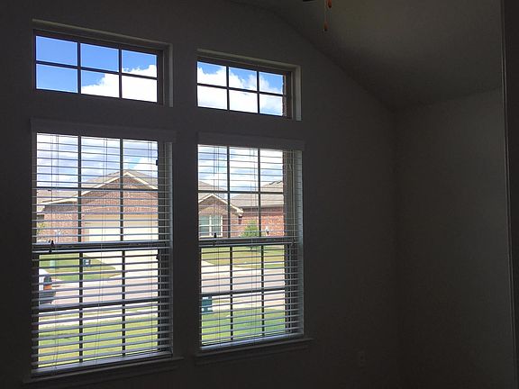 Front-facing secondary bedroom, with elevated ceiling, and transom windows. Note ceiling fans in all bedrooms, as well as great room!