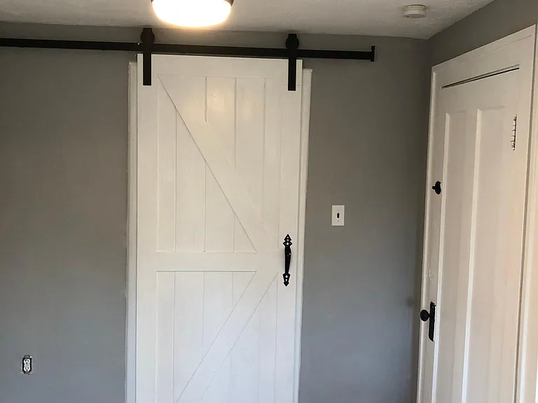 Barn door in closed position, one of 3 ceiling fans in LR