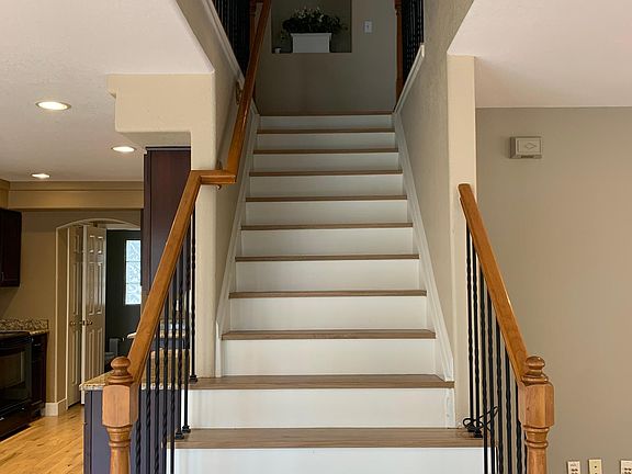 Steps going to 2nd floor with stylish wrought iron balusters.
