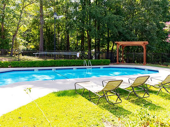 Outdoor swimming pool and deck complete with lounge chairs at Forest Ridge apartments for rent