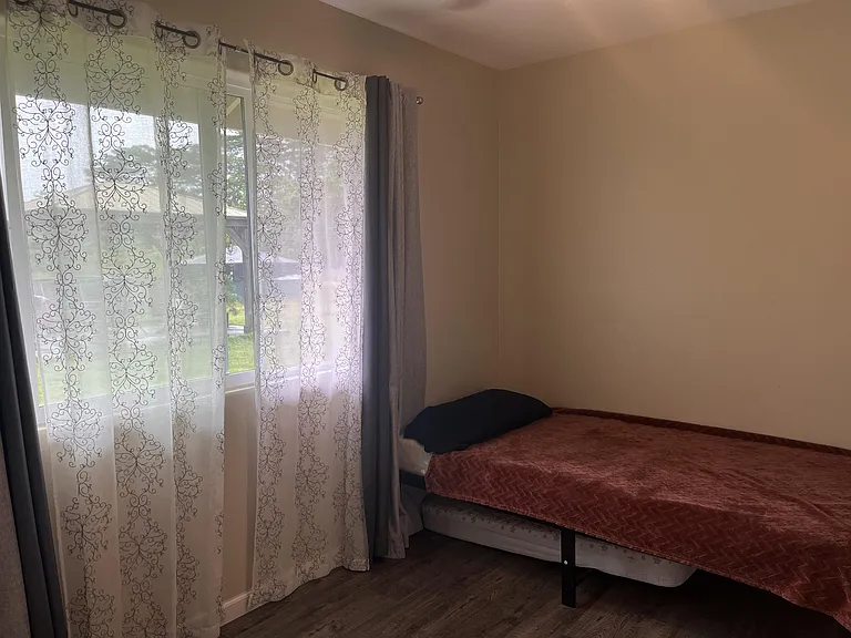 Bedroom 3 with bed, window looking to back yard, closet and dresser