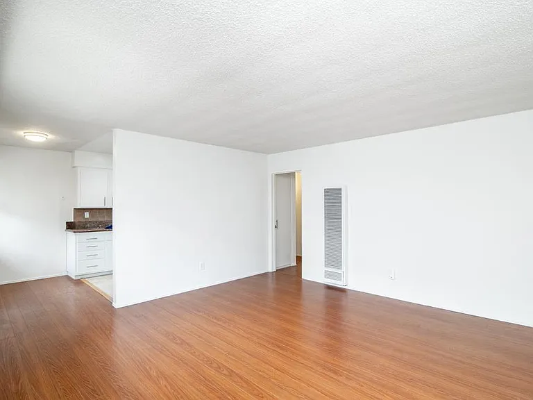 Living room with view towards kitchen and entry to hallway for bedrooms & bathroom