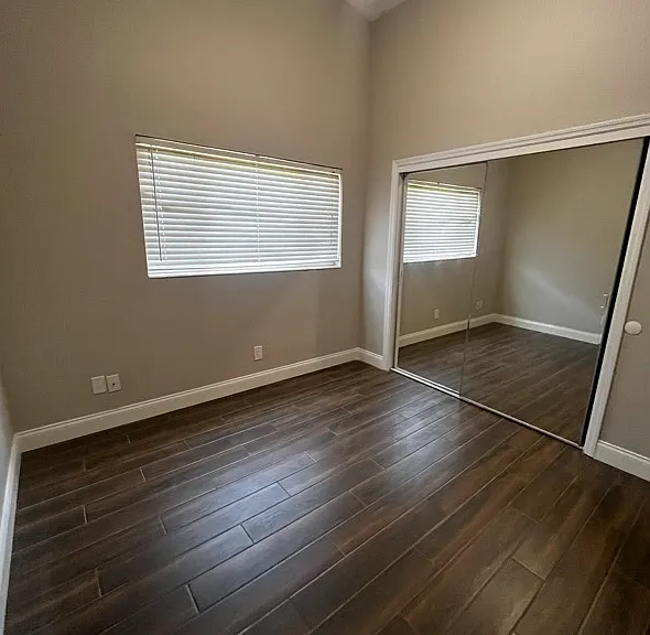 Bedroom #1: Ceiling fan with light, closet, wood look porcelain flooring.