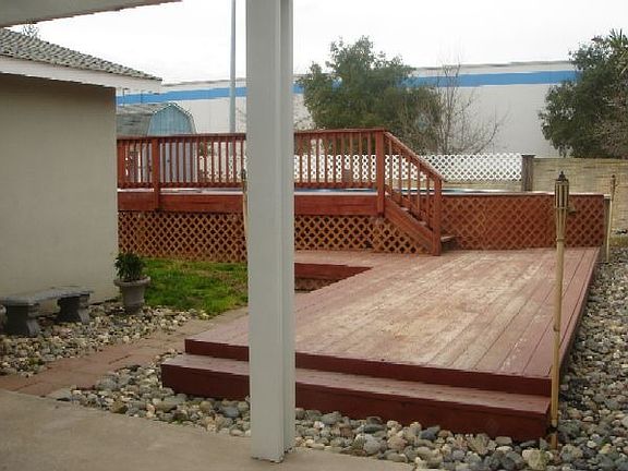 Pool with decking, covered patio, tool shed, easy-care landscaping