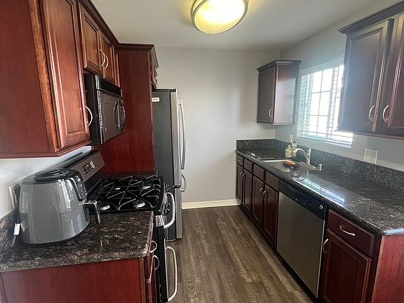 Kitchen with newer fridge. Gas stove. Microwave. Dishwasher. Air Fryer.