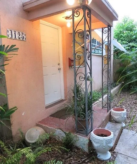 Delightful entry framed by wought iron