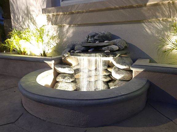 Evening view of fountain in front of home