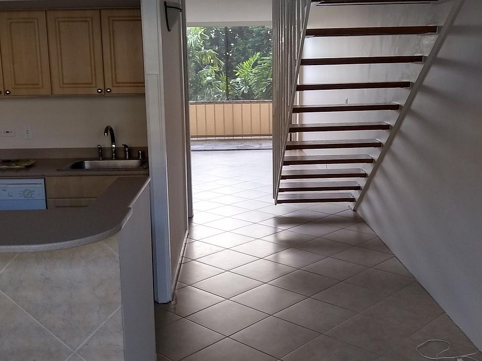 View through kitchen of stairs, living room and lanai