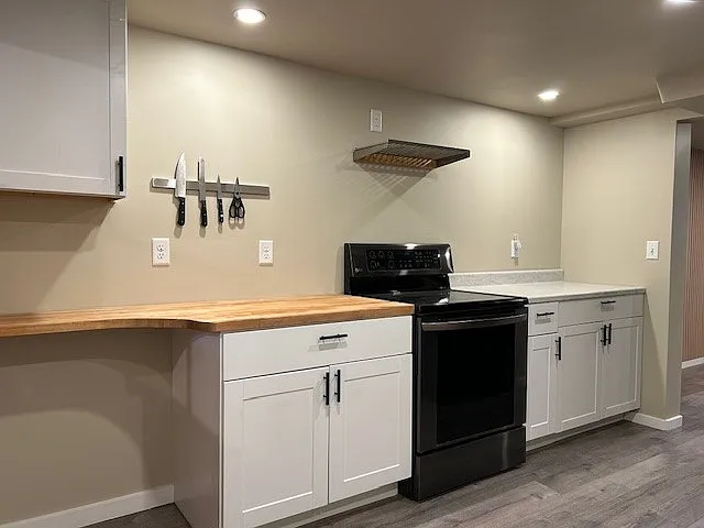 Spacious cooking area, magnetic knife holder above butcher block, stainless steel rack above stove - Imagine yourself cooking here!