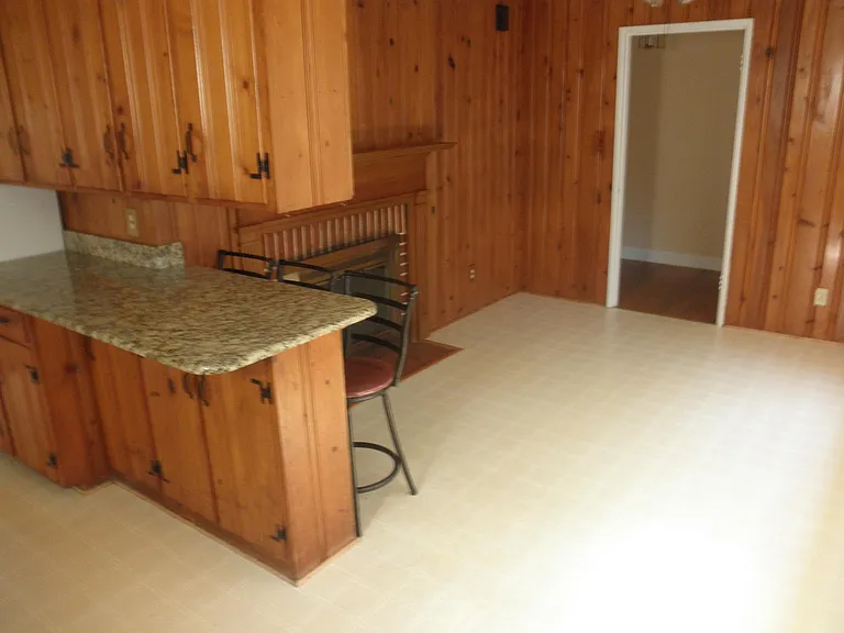 View from kitchen into the den area with fireplace.