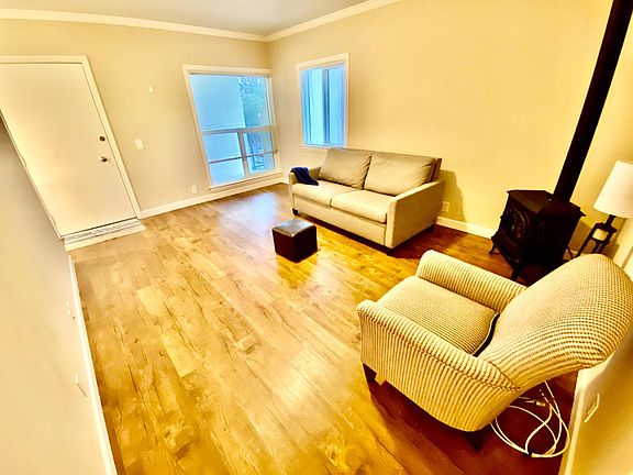 The door from outside to the living room which is spacious; lots of light a fireplace and semi furnitured or these pieces can be taken out